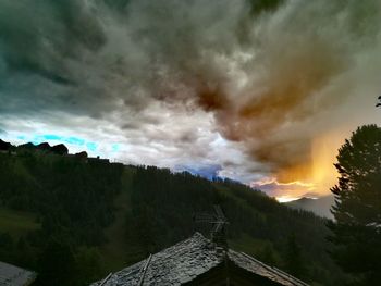 Scenic view of dramatic sky over mountains during sunset