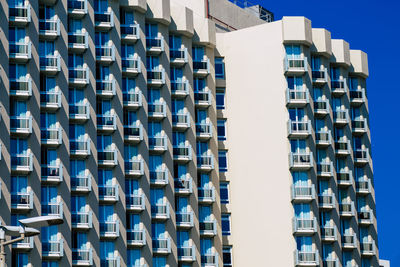 Low angle view of modern building against clear blue sky