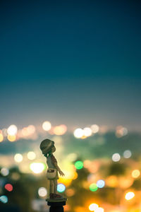 Defocused image of illuminated lights against sky at night