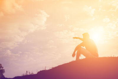 Side view of silhouette man standing against sky during sunset