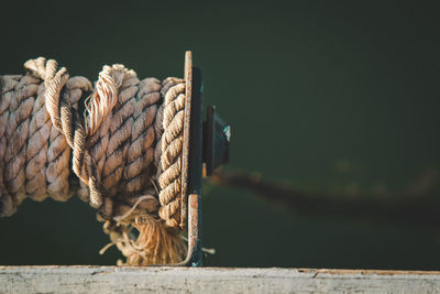 Close-up of rope rolled up on pulley at lake