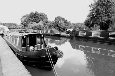 Boats moored on lake against sky