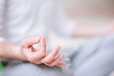 Midsection of man doing yoga in studio