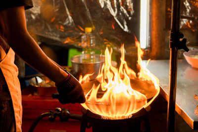 Midsection of chef preparing food in commercial kitchen