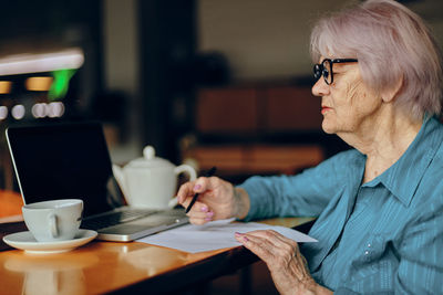 Senior woman talking on video call at cafe