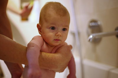 Cute little baby girl having shower in bathtub