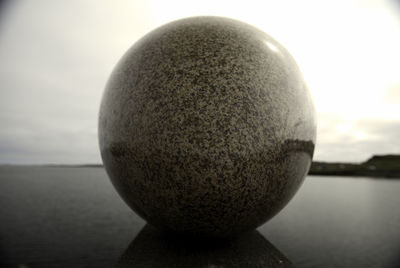 Close-up of ball on table against sky