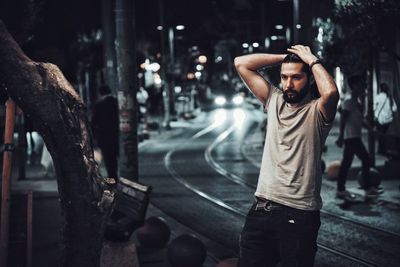 Young man standing on road in rain