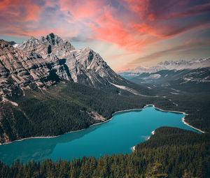 Scenic view of lake by mountains against sky during sunset