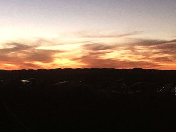 Scenic view of silhouette field against sky during sunset