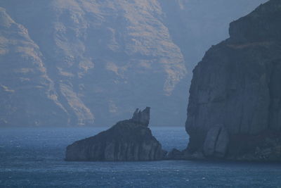 Scenic view of sea against mountain in santorini at aegean sea 