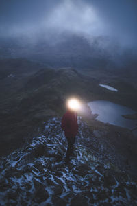 Rear view of man standing on snow covered land