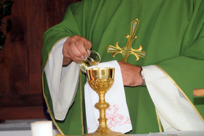 Midsection of man holding wineglass