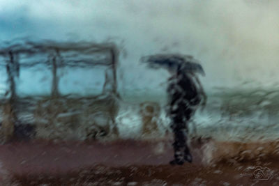 Person walking on wet street in rainy season