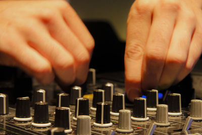 Cropped image of dj mixing with audio control equipment