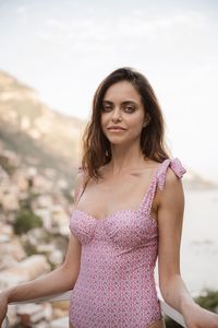 Portrait of young woman standing against sky