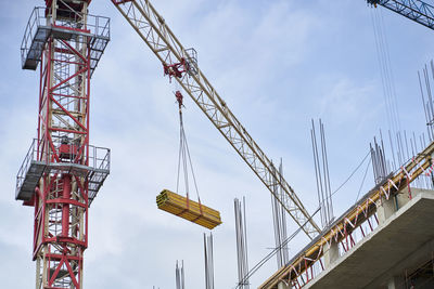 Low angle view of crane against sky