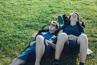 Friends relaxing on grassy field