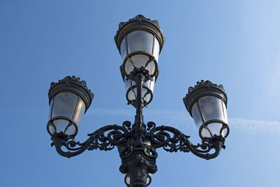 Low angle view of lamp against blue sky