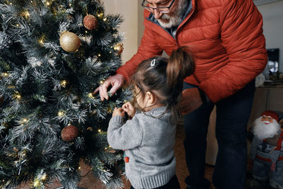 Rear view of people walking on christmas tree