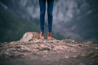 Low section of woman standing on rock