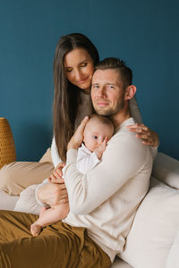 Portrait of a happy young family with their little son in dad's arms in the house person