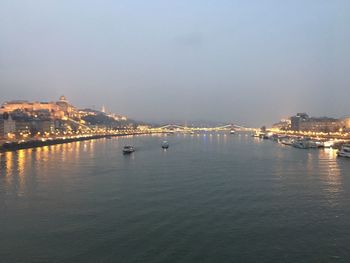 Scenic view of city by river against sky