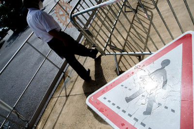 Low section of man sitting on footpath