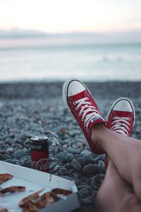 Low section of person wearing canvas shoes on beach