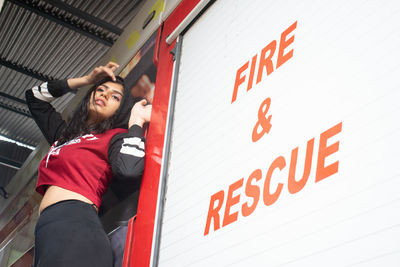 Low angle view of woman standing on fire truck