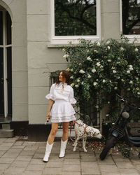 Rear view of woman standing in front of house