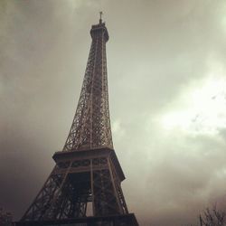 Low angle view of eiffel tower against cloudy sky