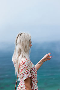 Woman looking at sea against sky