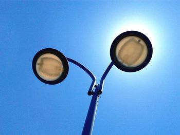 Low angle view of street light against blue sky