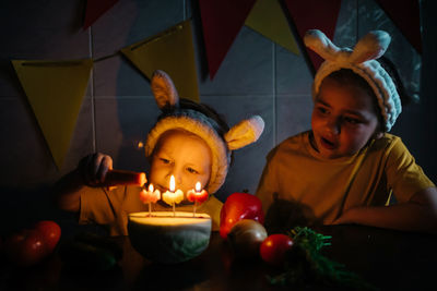 Vegetarian cake with candles birthday vegetables kids in bunny ears girl crying. high quality photo