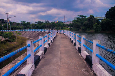 View of bridge over calm river against sky