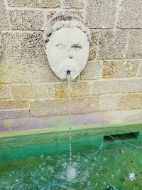 Close-up of fountain on wall by swimming pool