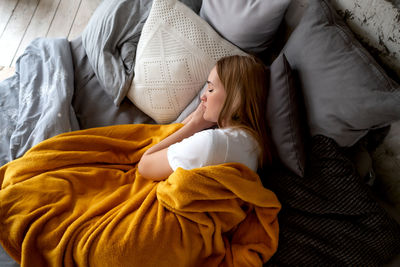 High angle view of woman sitting on bed at home