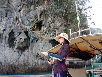 Woman taking selfie while standing on boat