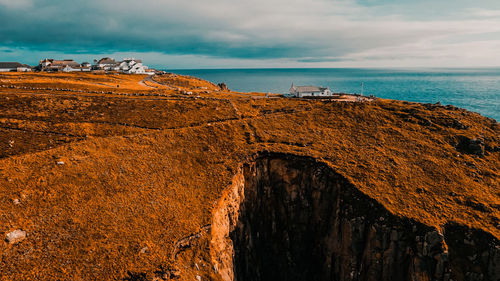 Building on the background of the ocean on top of a cliff aerial view