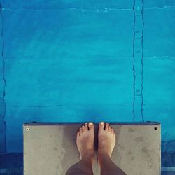 Low section of person standing on diving platform