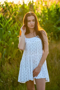 Young woman standing against plants