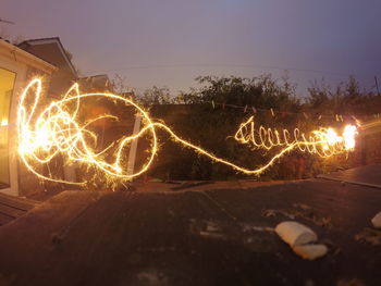 Close-up of illuminated lighting against sky at night