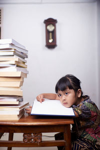 Portrait of young woman sitting on table