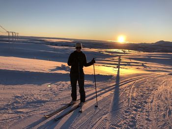 Rear view of man standing on snow covered land