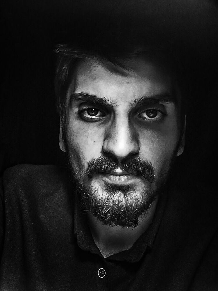 looking at camera, one person, young adult, human face, real people, evil, portrait, close-up, adult, people, black background, adults only, human body part, indoors, one man only