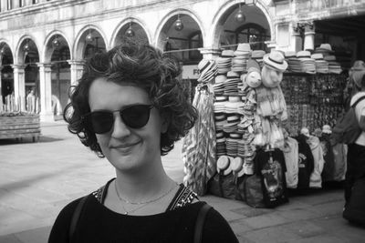 Portrait of woman wearing sunglasses while standing in city