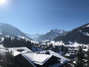 Houses by mountains against clear sky during winter