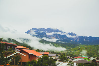 Houses on snowcapped mountain against sky