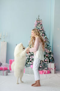 Full length of woman against white wall